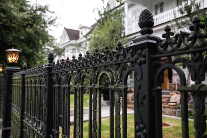 A white house surrounded by a wrought iron fence in New Orleans.
